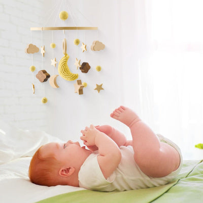 Bébé joyeux en regardant attentivement son mobile suspendu