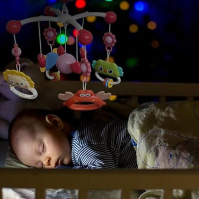 Bébé endormi et ses compagnons lumineux tournant au-dessus de lui