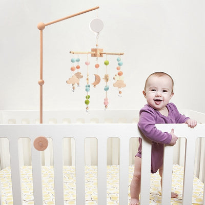 Bébé super content jouant avec son mobile pour bébé coloré suspendu  